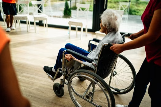 Senior sitting comfortably in a fitted adult wheelchair outdoors